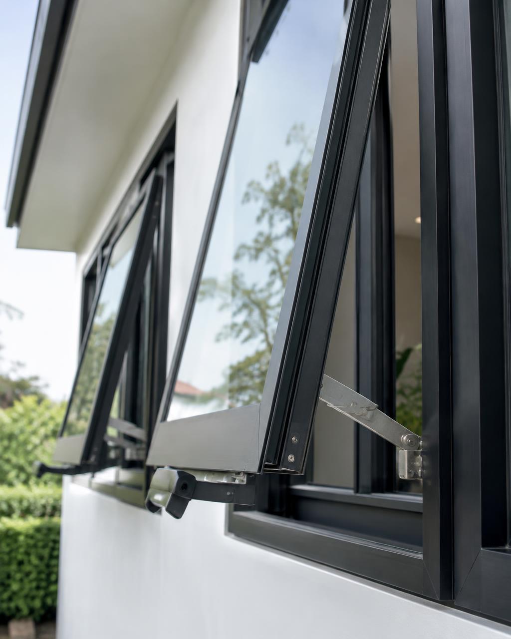 Black-framed casement windows opened outward on a white modern house
